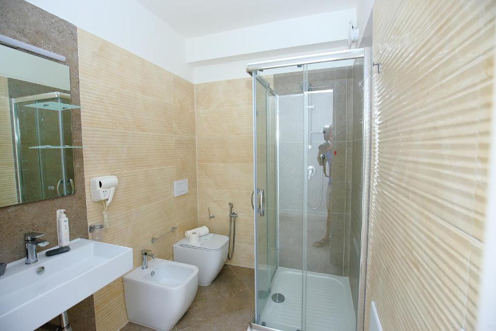 une salle de bain avec une douche, des toilettes et un lavabo dans l'établissement Sand Hotel, à Botricello