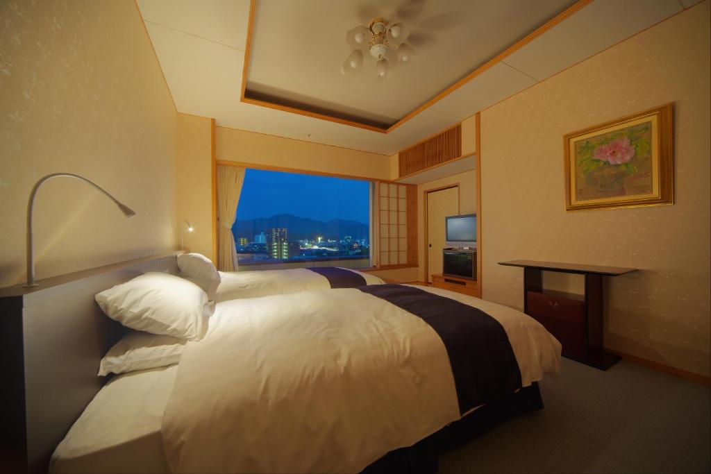 une chambre d'hôtel avec un lit et une fenêtre dans l'établissement Jyoseikan, à Kōchi 37 autres photos