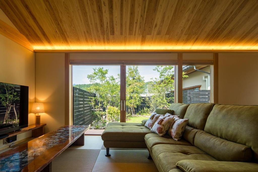 un salon avec un canapé et une grande fenêtre dans l'établissement 宿坊　心月, à Arita