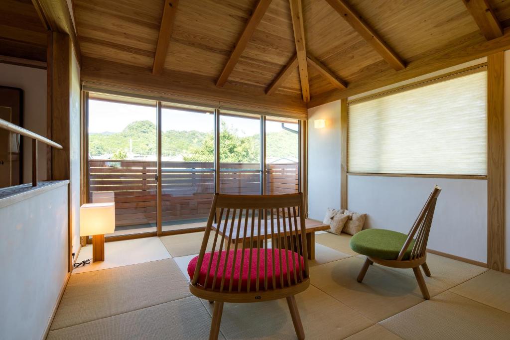 une chambre avec deux chaises, une table et une fenêtre dans l'établissement 宿坊　心月, à Arita