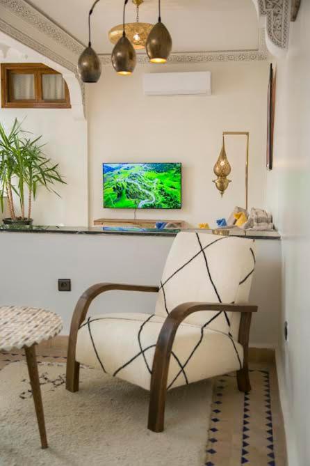 un salon avec une chaise et une table dans l'établissement Riad Sabria, à Marrakech