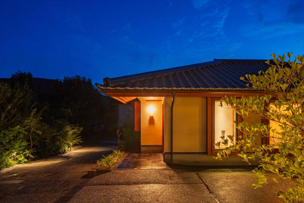 un bâtiment lumineux sur le côté d'une route dans l'établissement 宿坊　心月, à Arita