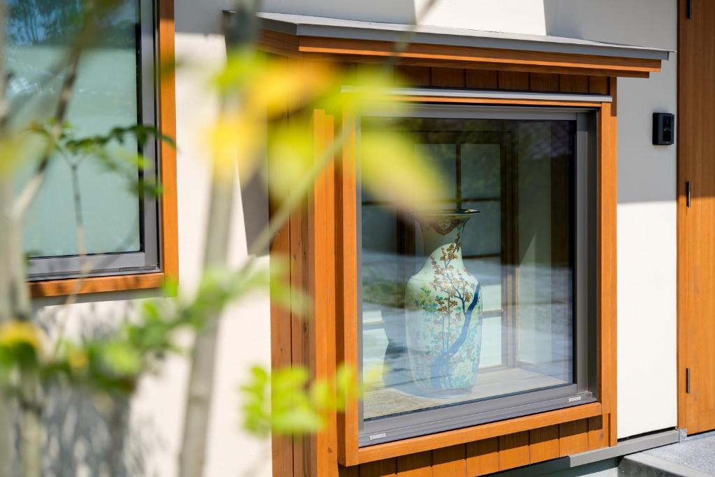 un vase bleu et blanc assis dans une fenêtre dans l'établissement 宿坊　心月, à Arita