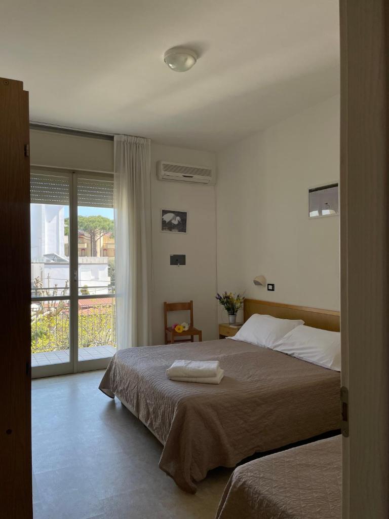 une chambre avec un lit et un balcon dans l'établissement HOTEL LA PLAYA, à Cervia