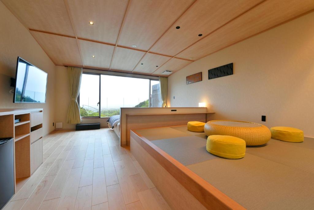 une chambre avec deux lits avec des coussins jaunes dedans dans l'établissement Takimotokan Yuki No Sato, à Yoro