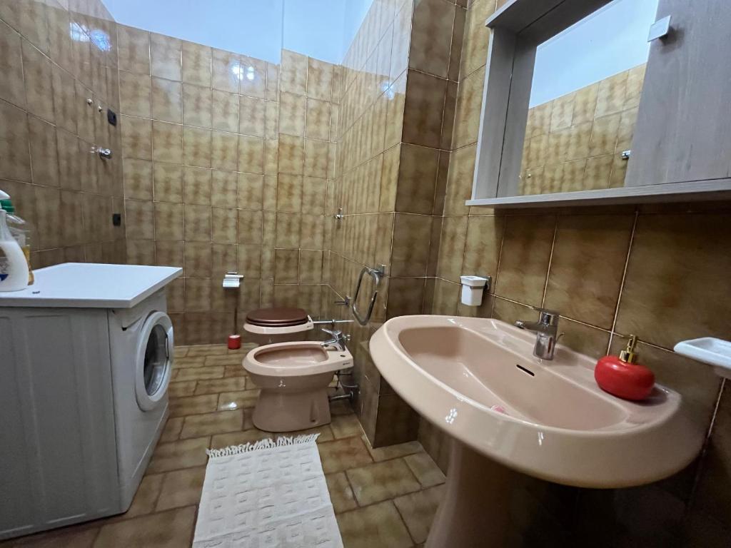 une salle de bain avec un lavabo, des toilettes et un miroir dans l'établissement Casa Morello, à Zambrone