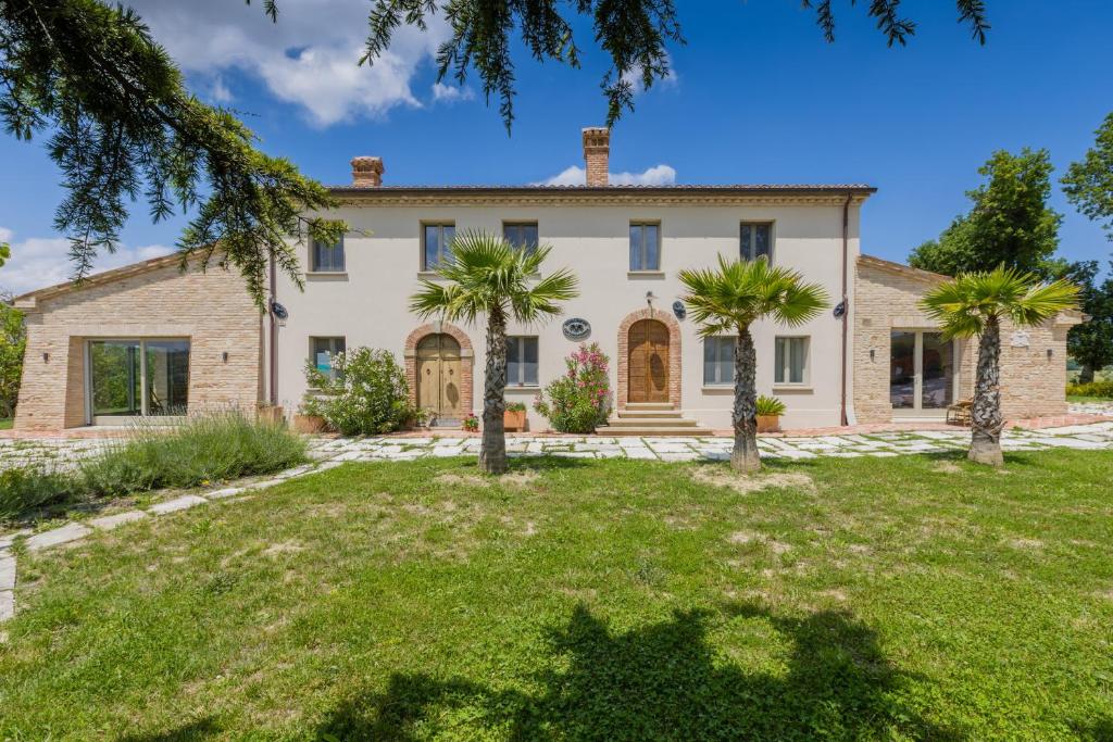 une maison avec des palmiers devant dans l'établissement Villa Michela, à Barchi