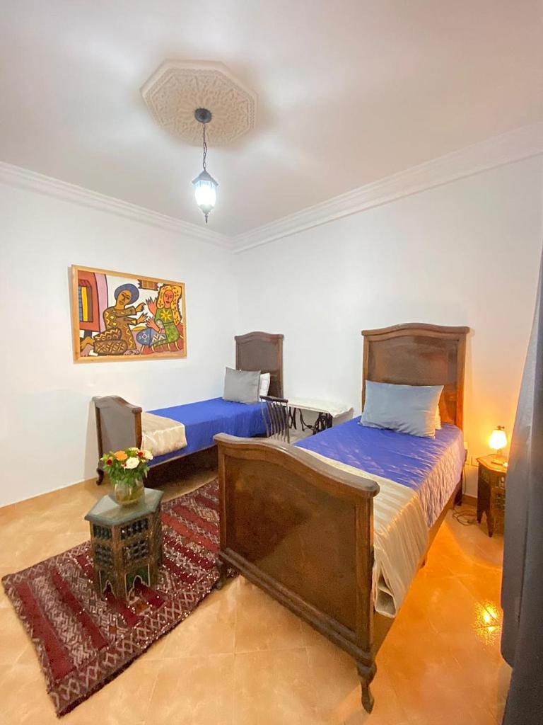 une chambre avec deux lits et un tapis dans l'établissement Dar Baddi, à Marrakech 37 autres photos
