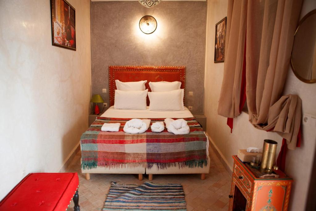 une chambre avec un lit avec des serviettes dessus dans l'établissement Riad Achwaq, à Marrakech