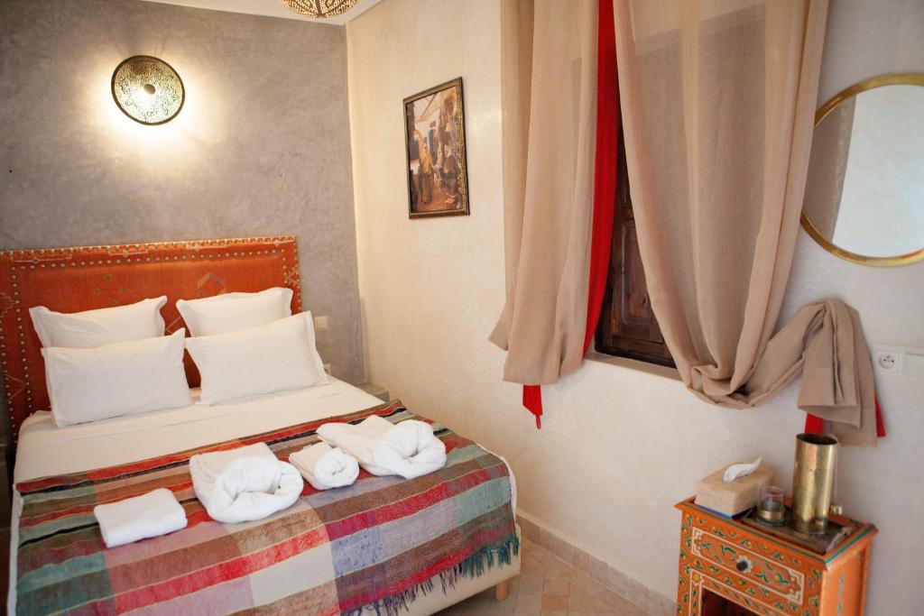 une chambre avec un lit avec des serviettes dessus dans l'établissement Riad Achwaq, à Marrakech