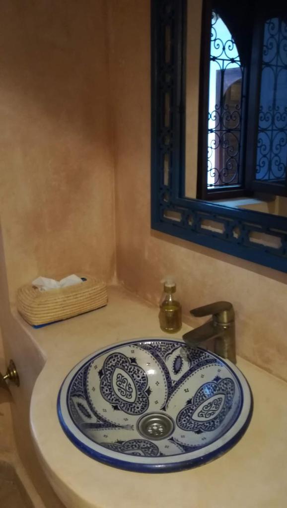 - un lavabo dans la salle de bains avec une plaque bleue et blanche dans l'établissement Riad Achwaq, à Marrakech 35 autres photos