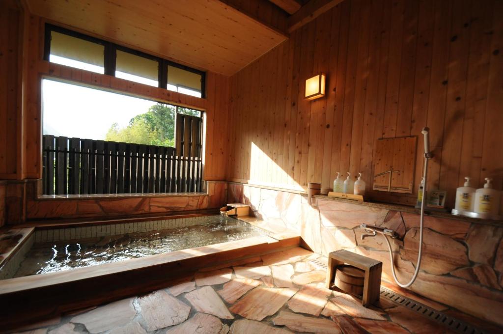 La salle de bains est pourvue d'une baignoire et d'une fenêtre. dans l'établissement Super Hydrogen Rich Spa Yado Kanzan, à Minakami