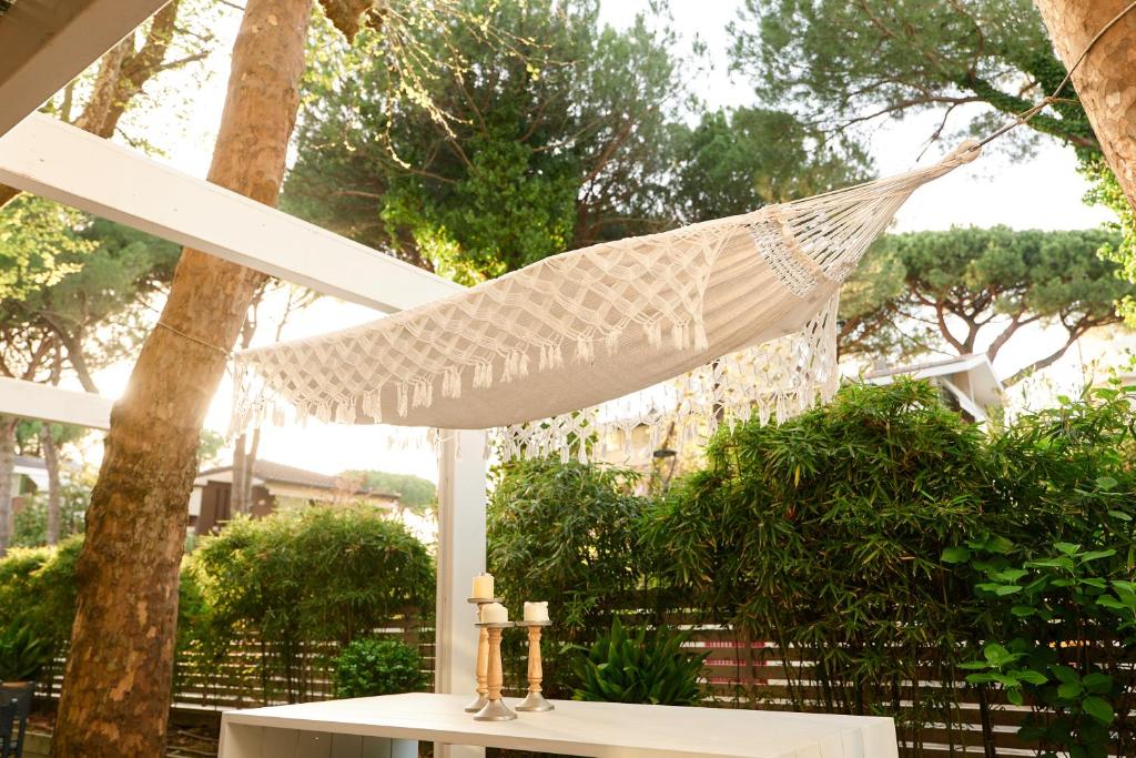 un hamac dans un patio avec une table avec des bougies dans l'établissement Hotel Saraceno Resort with Private Beach, à Milano Marittima