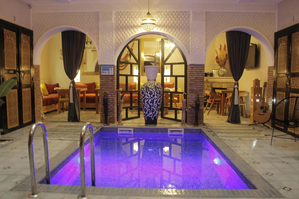 - une piscine avec des lumières violettes dans le salon dans l'établissement Riad Les Gazelles D'Orient Marrakech, à Marrakech