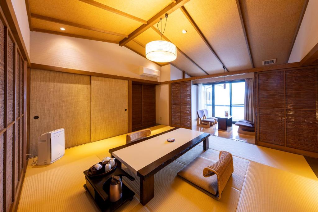 une salle à manger avec une table et des chaises dans une pièce dans l'établissement Taiseikan, à Atami