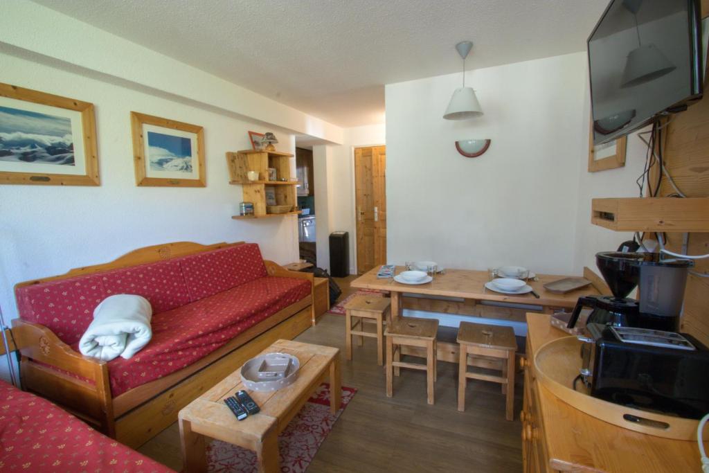 un salon avec un canapé rouge et une table dans l'établissement Tignes - Résidence Le Borsat au pied des pistes (4 personnes), à Tignes 3 autres photos