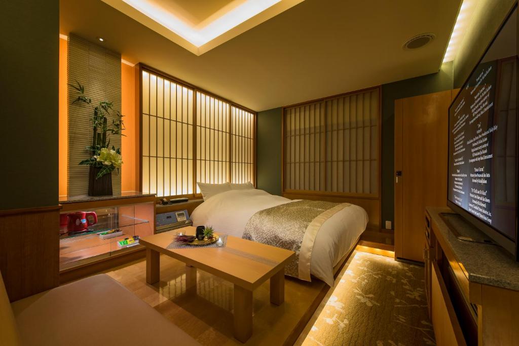 une chambre avec un lit, une table et une télévision dans l'établissement コスタリゾート千葉北（大人専用）, à Shimo-shizu