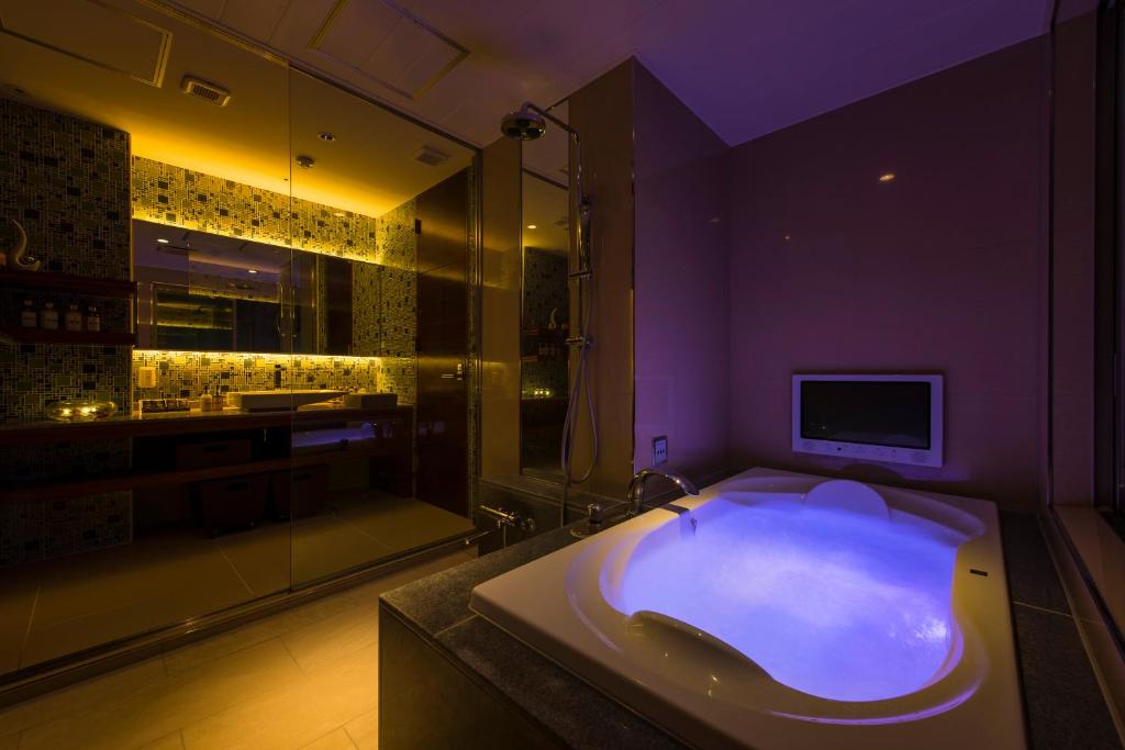 La salle de bains est pourvue d'une baignoire, d'une télévision et d'une douche. dans l'établissement コスタリゾート千葉北（大人専用）, à Shimo-shizu