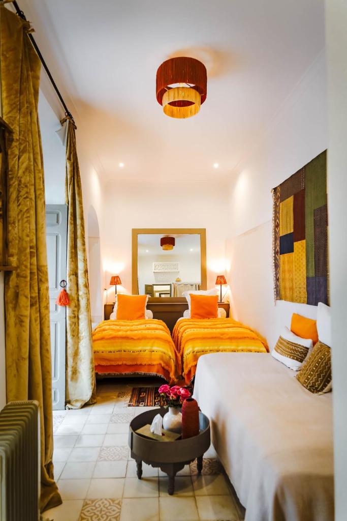 une chambre d'hôtel avec deux lits et un miroir dans l'établissement Riad Dar Aman, à Marrakech