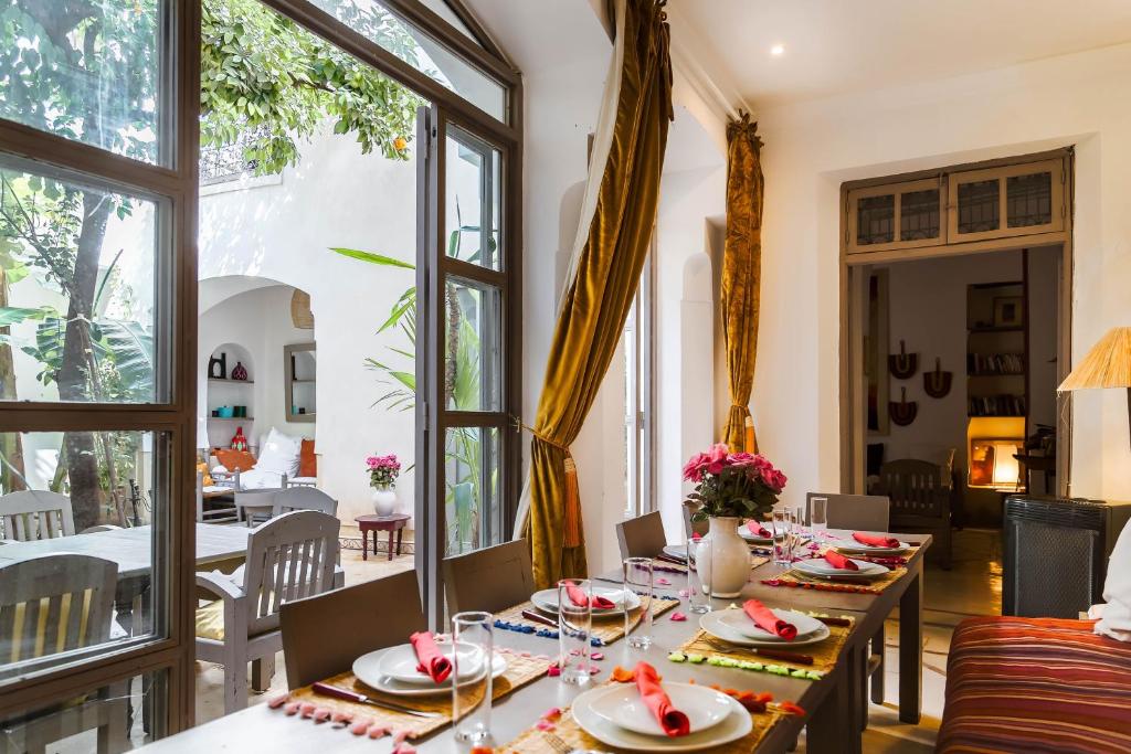 une salle à manger avec tables, chaises et fenêtres dans l'établissement Riad Dar Aman, à Marrakech 37 autres photos