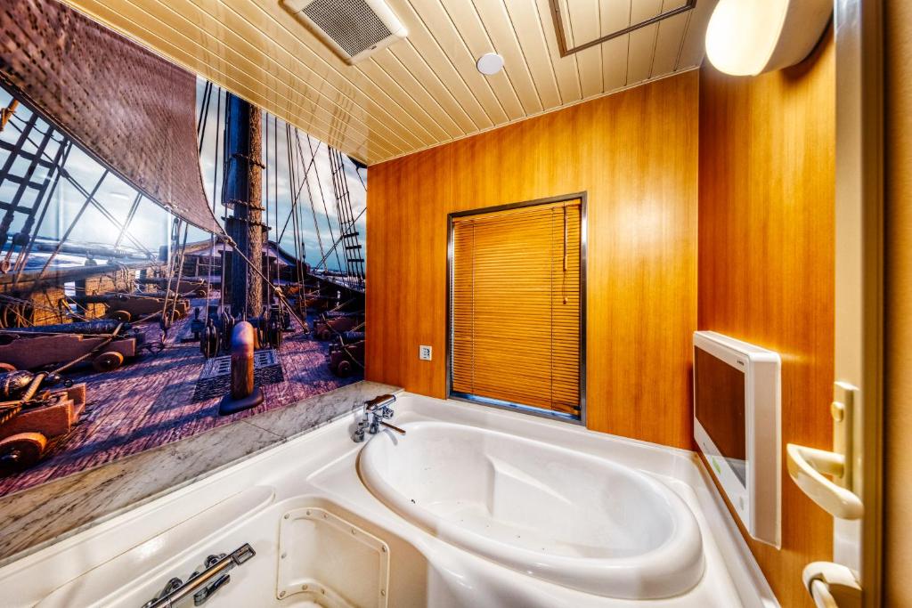 une salle de bain avec une grande baignoire et une grande fenêtre dans l'établissement Hotel Atlantis Machida -Adult Only, à Kami-seya