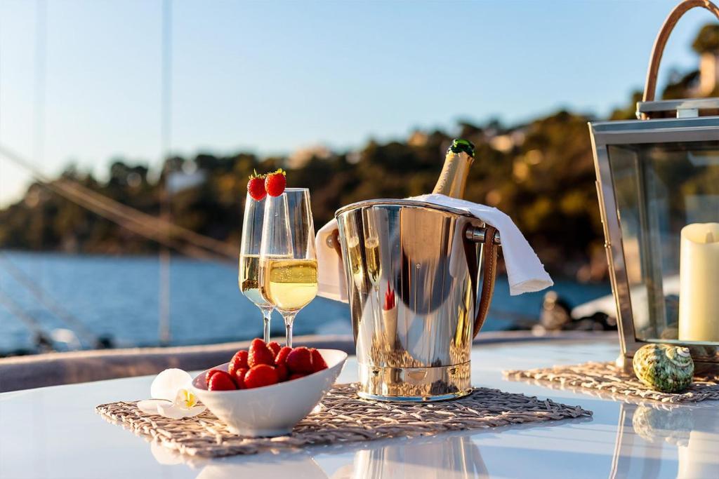 - une table avec un verre de vin et un bol de fraises dans l'établissement Yacht idéalement situé au coeur du Vieux-Port, à Marseille