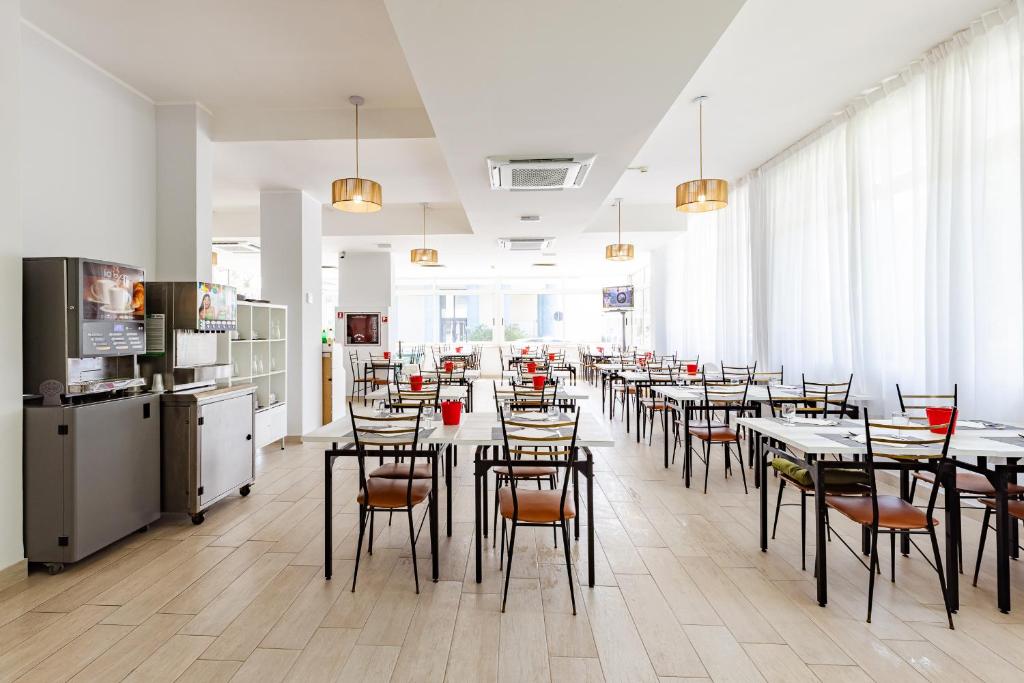 un restaurant avec des tables et des chaises dans une salle dans l'établissement Hotel Sorriso, à Misano Adriatico