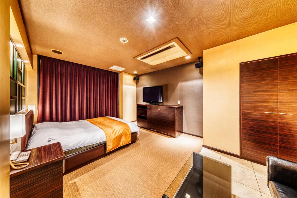 une chambre d'hôtel avec un lit et une télévision dans l'établissement HOTEL LITZ HIROSHIMA -Adult Only, à Hiroshima