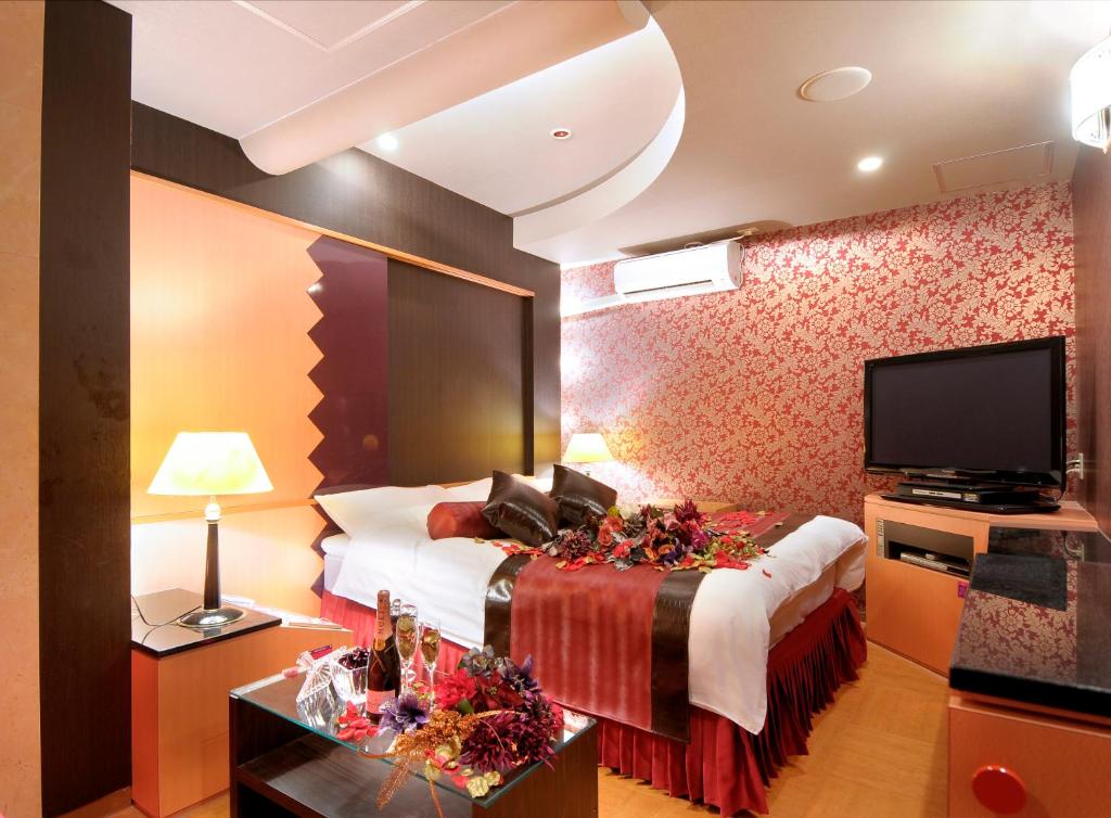 une chambre d'hôtel avec un lit et une télévision à écran plat dans l'établissement HOTEL ATLANTIS IKUTAMA -Adult Only, à Osaka