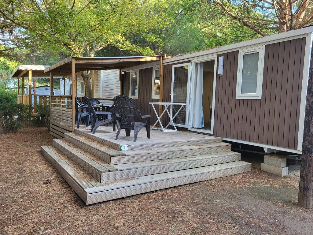 une maison avec une terrasse avec une table et des chaises dans l'établissement mobilhome 6 personnes, à Saint-Cyprien