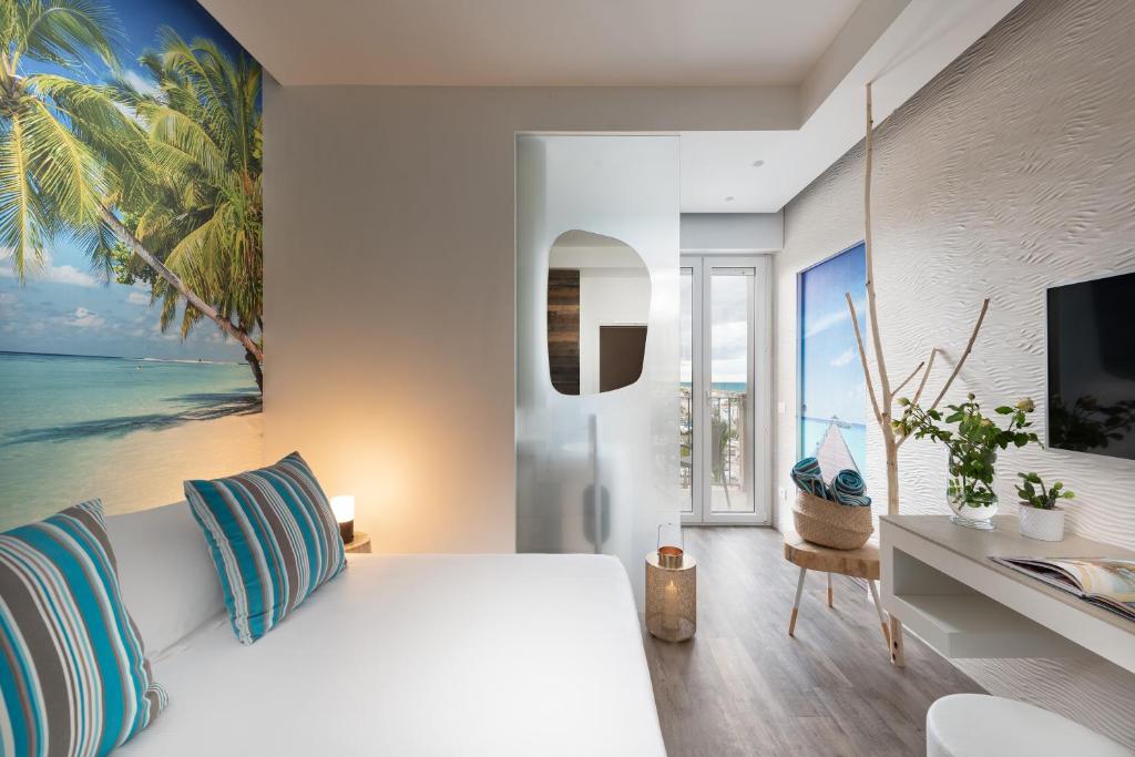- une chambre avec un lit blanc et un bureau avec une télévision dans l'établissement Hotel Liberty Beach - Parking & Beach, à Riccione