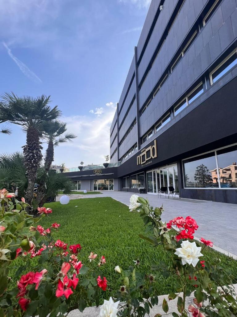 un bâtiment avec beaucoup de fleurs devant lui dans l'établissement Mood Hotel, à Citta' Sant'Angelo