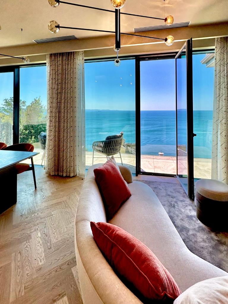 un salon avec un canapé et une vue sur l'océan dans l'établissement Maximilian Suites, à Trieste