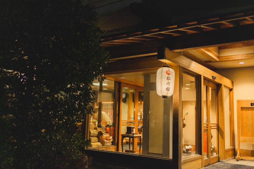 un bâtiment avec une enseigne sur le côté dans l'établissement The TOJIBA 松川館, à Takayama