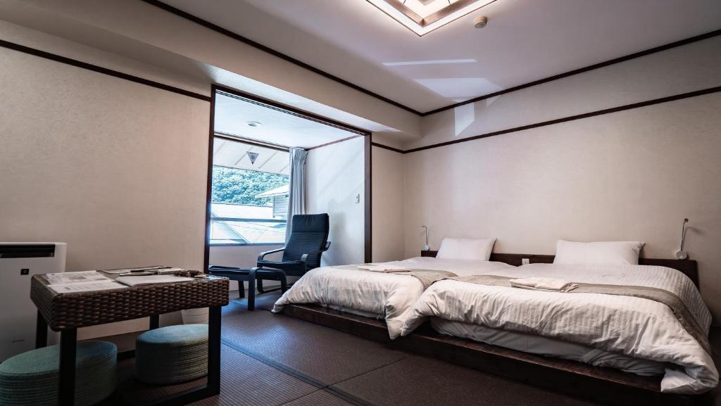 une chambre avec un lit, un bureau et une fenêtre dans l'établissement The TOJIBA 松川館, à Takayama