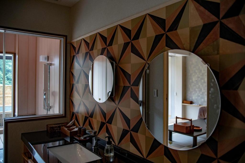 une salle de bain avec un miroir et un lavabo dans l'établissement Senkei, à Hakone