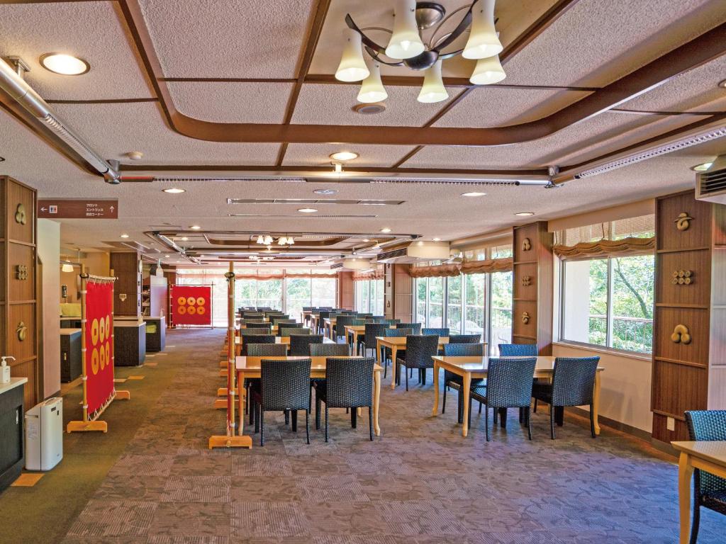 une salle à manger avec tables, chaises et fenêtres dans l'établissement 真田昌幸-幸村父子の隠れ宿 紀伊見荘, à Hashimoto 37 autres photos