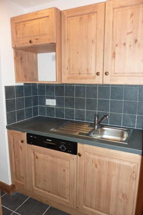 - une cuisine avec un évier, une cuisinière et des placards dans l'établissement Reine Blanche Appartements VTI, à Val Thorens 37 autres photos