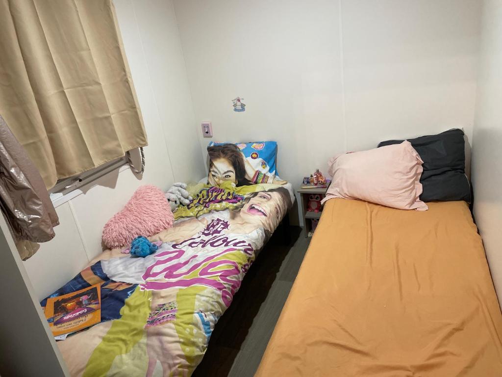- une fille dormant dans un lit dans une chambre avec 2 lits dans l'établissement Mobil-home 4/6 personnes dans un camping 4 étoiles, à Lège-Cap-Ferret