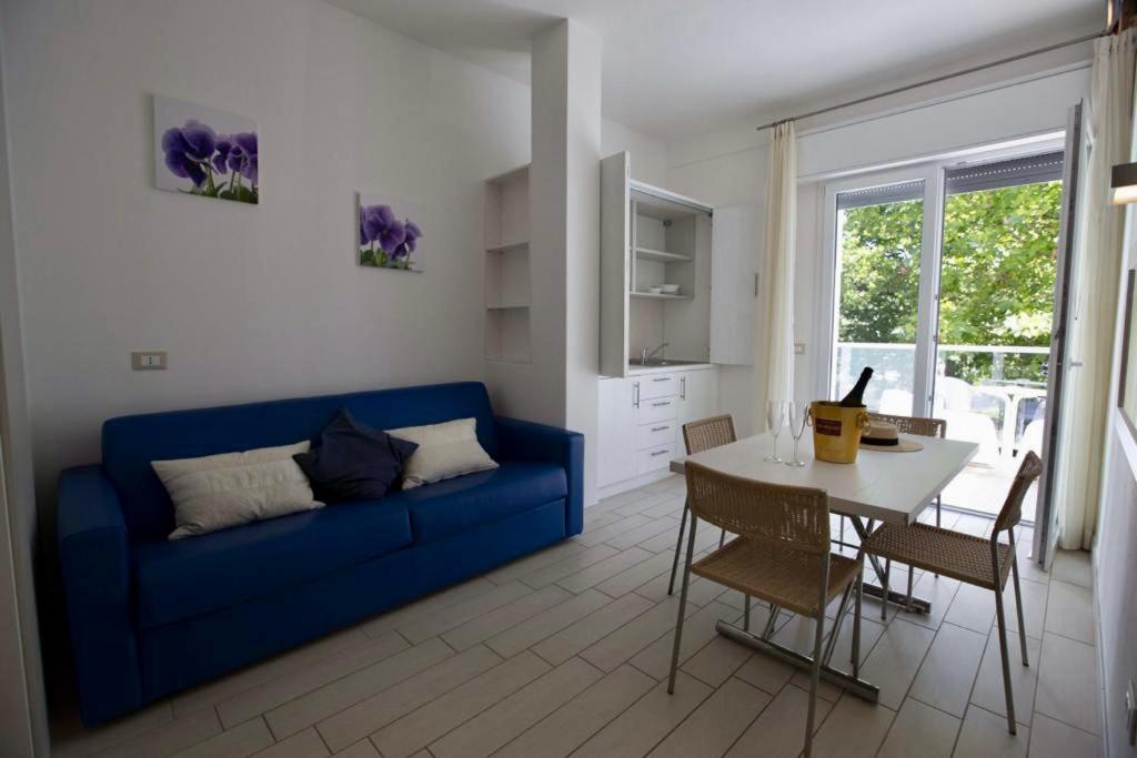 un salon avec un canapé bleu et une table dans l'établissement Hotel Elite, à Cervia