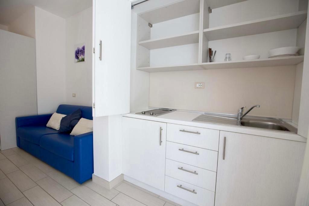 une cuisine avec un évier et un canapé bleu dans l'établissement Hotel Elite, à Cervia