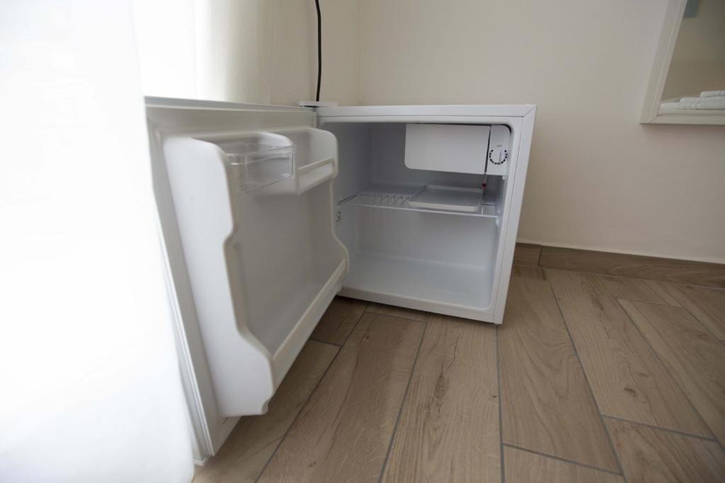 - un réfrigérateur blanc avec une porte ouverte dans la chambre dans l'établissement Hotel Elite, à Cervia