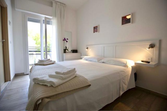 - une chambre blanche avec un grand lit et des serviettes dans l'établissement Hotel Elite, à Cervia 184 autres photos