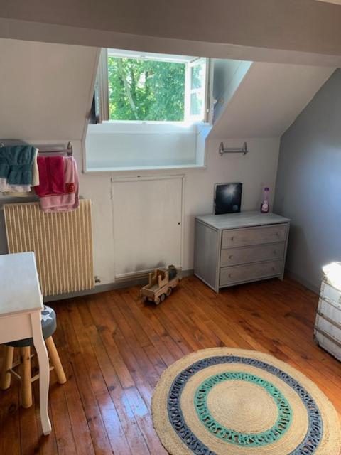 une chambre mansardée avec un bureau et un tapis dans l'établissement GÎTE VIGNERAIE, à Sainte-Gemme-Moronval