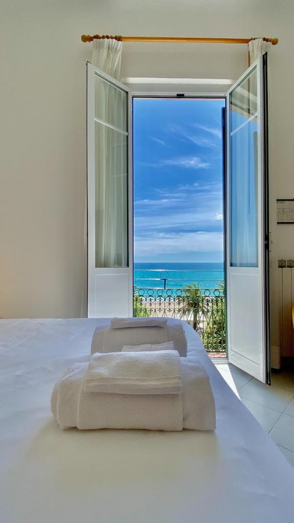 une chambre avec un lit et une vue sur l'océan dans l'établissement Hotel Alba Chiara, à Finale Ligure