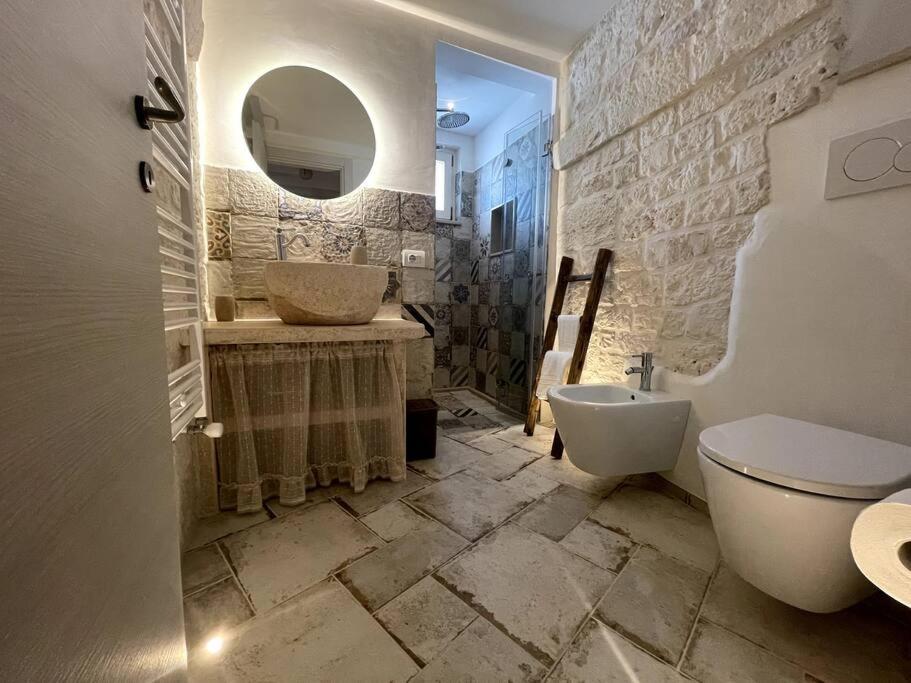 une salle de bain avec deux lavabos et un WC et un miroir dans l'établissement SUITE - Trullo Relax sul Monte, à Cisternino 29 autres photos
