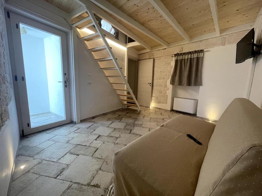 un salon avec un canapé et un escalier dans l'établissement SUITE - Trullo Relax sul Monte, à Cisternino