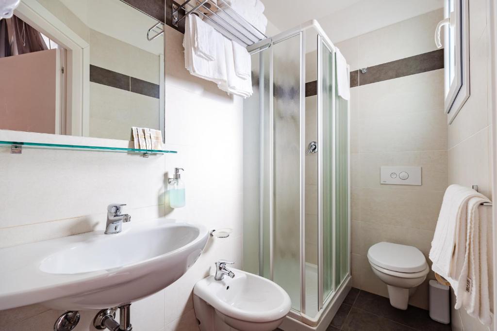 une salle de bain avec un lavabo, des toilettes et une douche dans l'établissement Hotel Sorriso, à Misano Adriatico