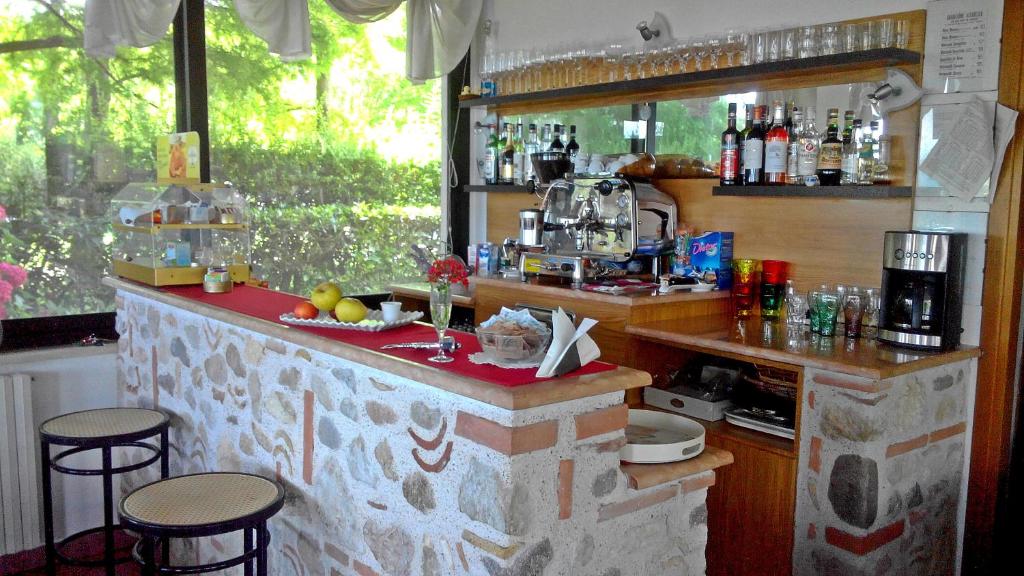 - une cuisine avec un comptoir et quelques tabourets dans l'établissement Albergo Il Biancospino, à Sirmione