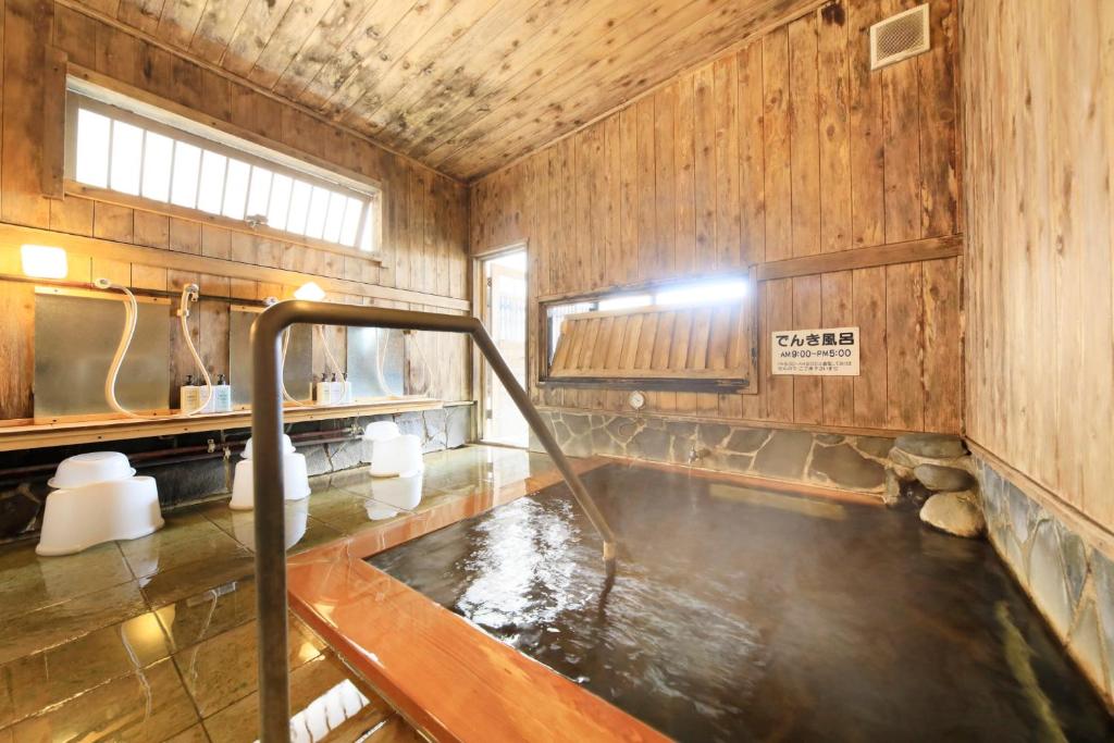 La salle de bains est pourvue d'une baignoire avec de l'eau. dans l'établissement Hotel Pony Onsen, à Towada